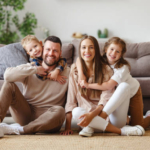 happy family mother father and children at home on the couch